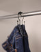Jeans hanging from a jeans hook on the closet rail