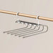 Pants hanger with six bars hanging empty on a wooden rail